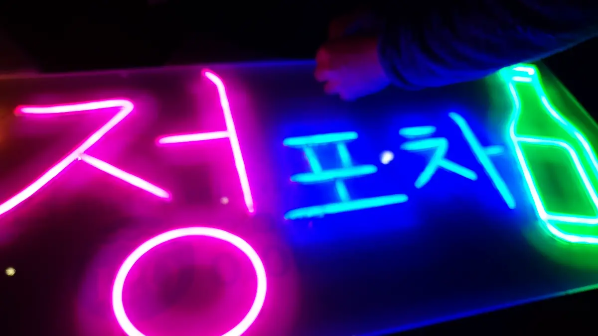 소주네온사인 노란색 초승달과 녹색 병이 어우러진 모습