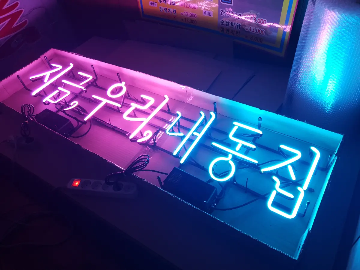 내동집 네온사인 손글씨체로 작성된 지금 우리내동집 텍스트