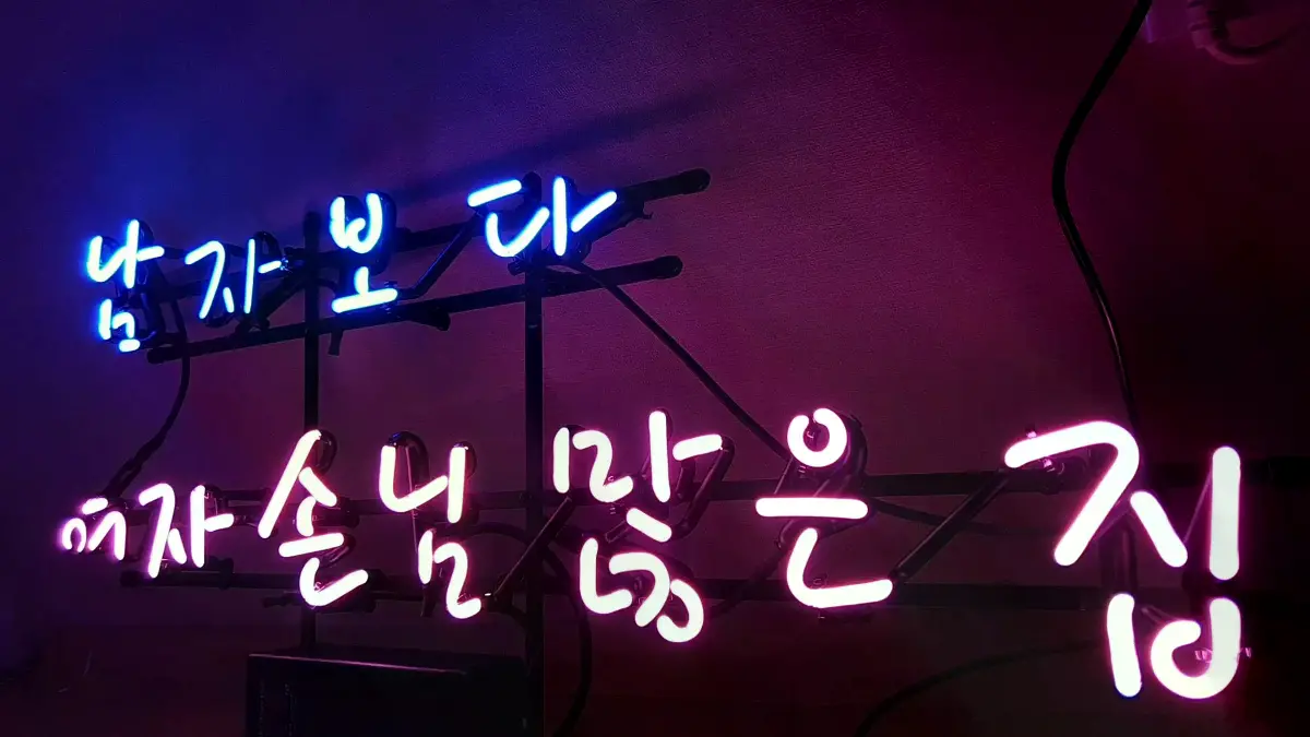 둥근 손글씨로 두 줄을 나눈 청색과 핑크색 미용실 네온 간판
