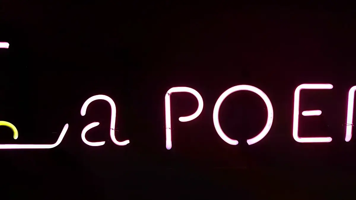 핑크색 La POEM 영문과 첫 글자 L 아래 노란색 곡선이 있는 스튜디오네온사인