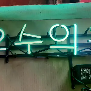 녹색과 핑크색 문구로 안내 내용을 보여주는 은행네온사인