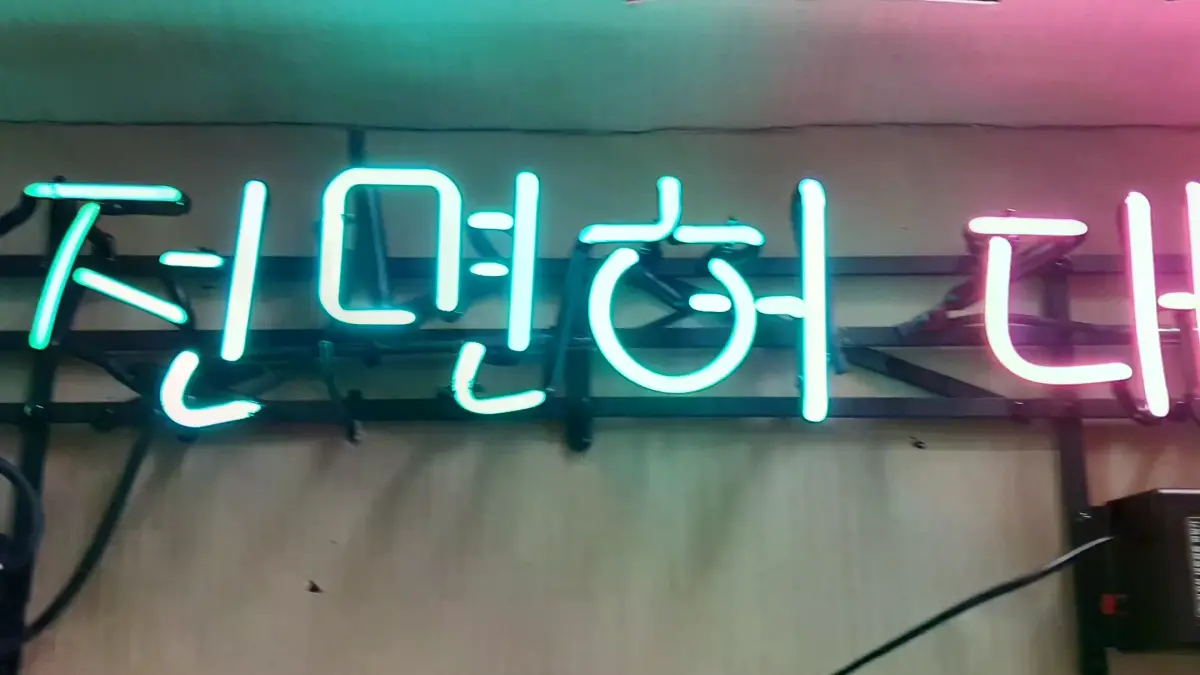 은행 네온사인 녹색 운수의 운전면허 문구가 강조된 모습