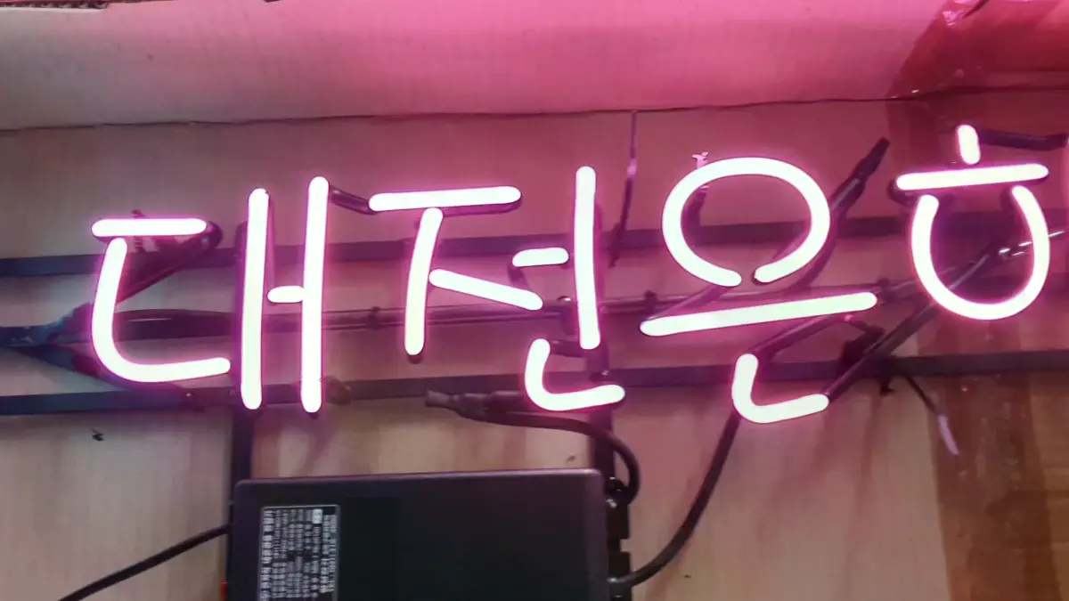 은행 네온사인글씨 핑크색과 녹색으로 표현된 문구 조합