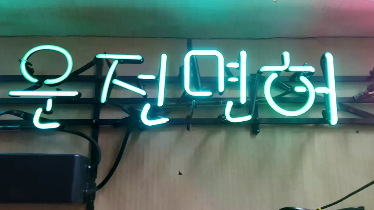 은행 네온사인 녹색 운수의 운전면허와 핑크색 글씨 조합